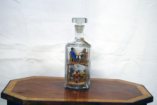 Flasche mit Holzfiguren.